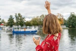 Frau winkt von Boot zu anderem Boot auf Wasser